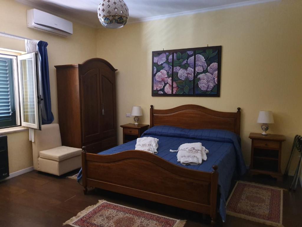 ein Schlafzimmer mit einem blauen Bett mit zwei Handtüchern darauf in der Unterkunft Villa la Quercia Resort in San Salvatore Telesino