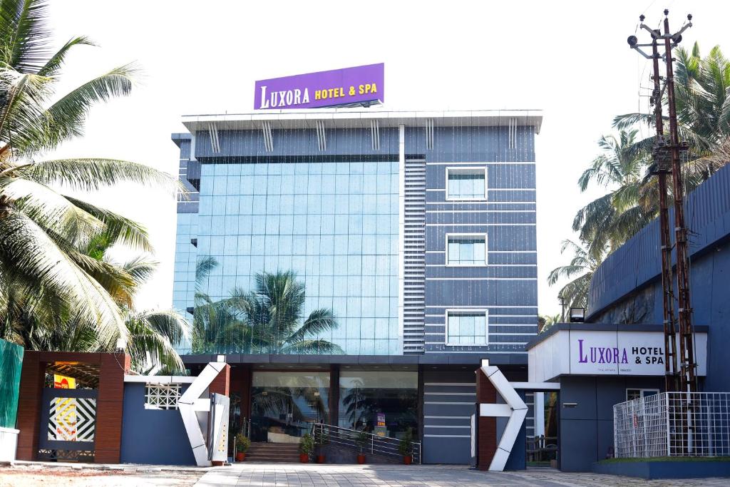 科泽科德Luxora Hotel and Spa的顶部有标志的建筑物