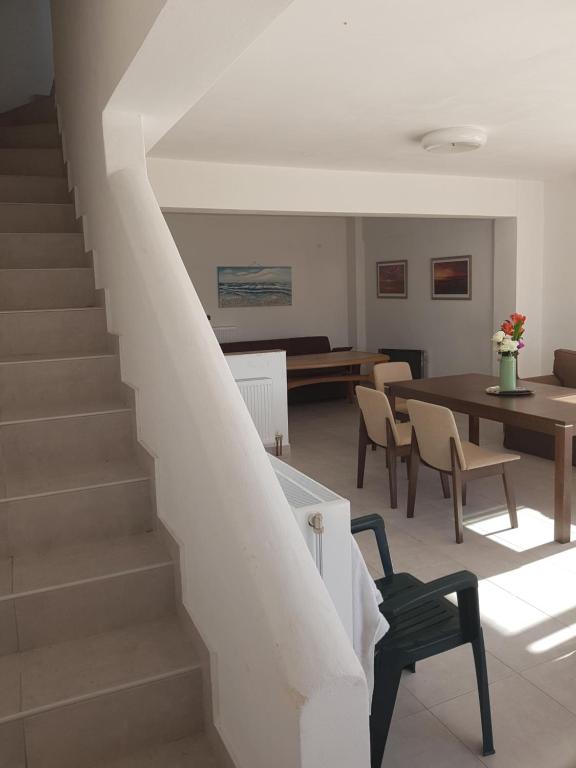 a staircase in a living room with a table and chairs at MAREMARI VILLA in Ayía Marína