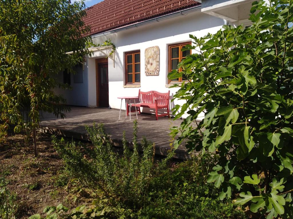 a porch of a white house with two red chairs at Gästehaus Wahlhütter in Doiber