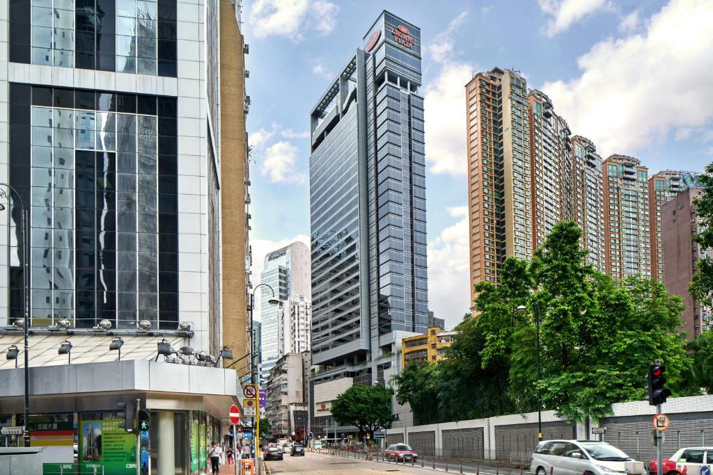 uma cidade com edifícios altos e carros numa rua em Crowne Plaza Hong Kong Causeway Bay, an IHG Hotel em Hong Kong