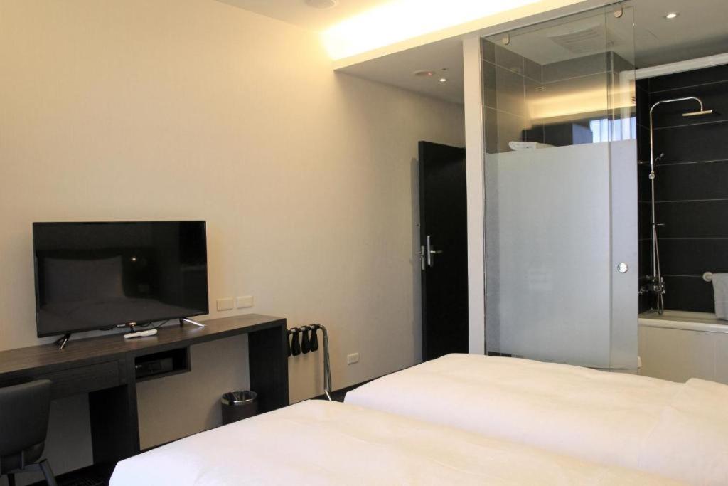 a hotel room with two beds and a television at Capital Hotel SongShan in Taipei