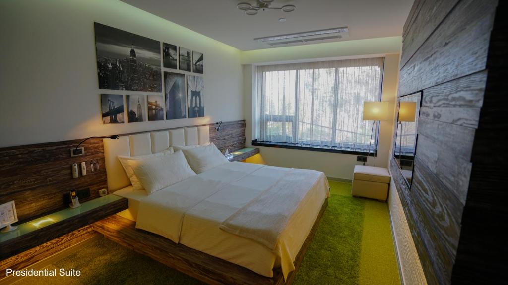 a bedroom with a white bed and a large window at Hayali Boutique Hotel in Erbil