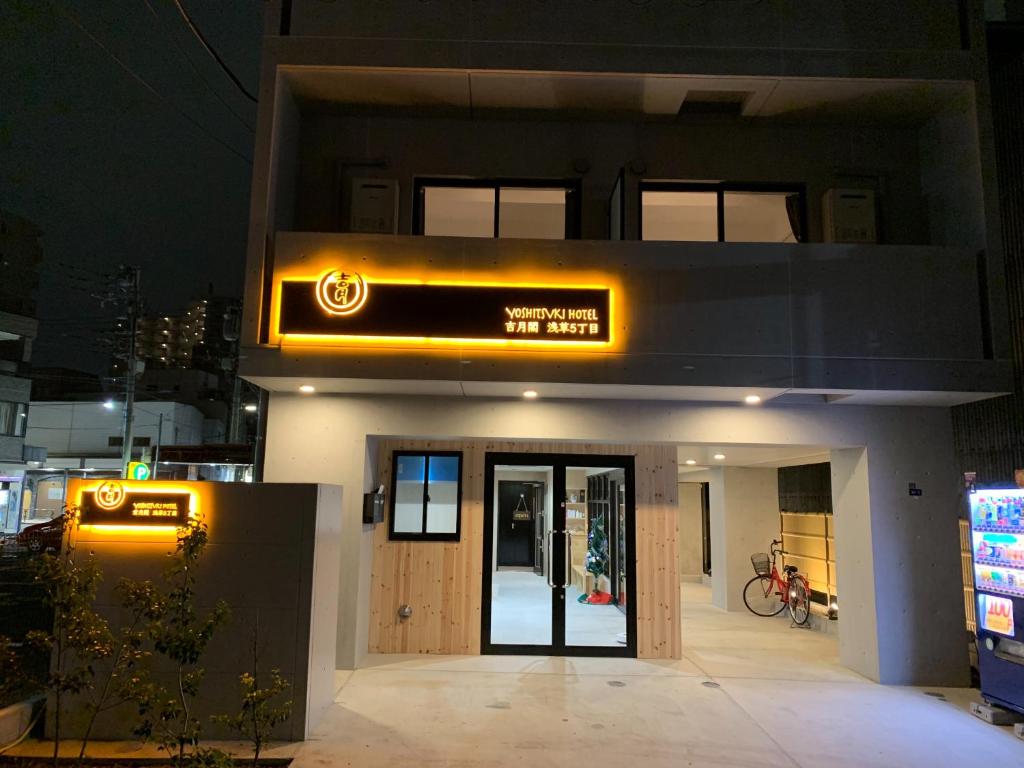uma frente de loja com uma placa à noite em Yoshitsuki kaku - Yoshitsuki Apart Hotel em Tóquio