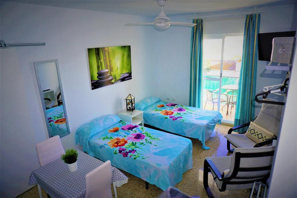 salon z 2 łóżkami i krzesłem w obiekcie LOFT - GARAJE - TERRAZA PRIVADA Junto al Parque y Playa w mieście Conil de la Frontera