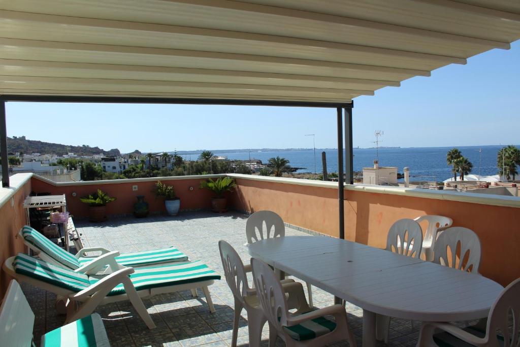 una mesa y sillas en un balcón con vistas al océano en Splendida casa con vista sulla Baia di Gallipoli, en Nardò