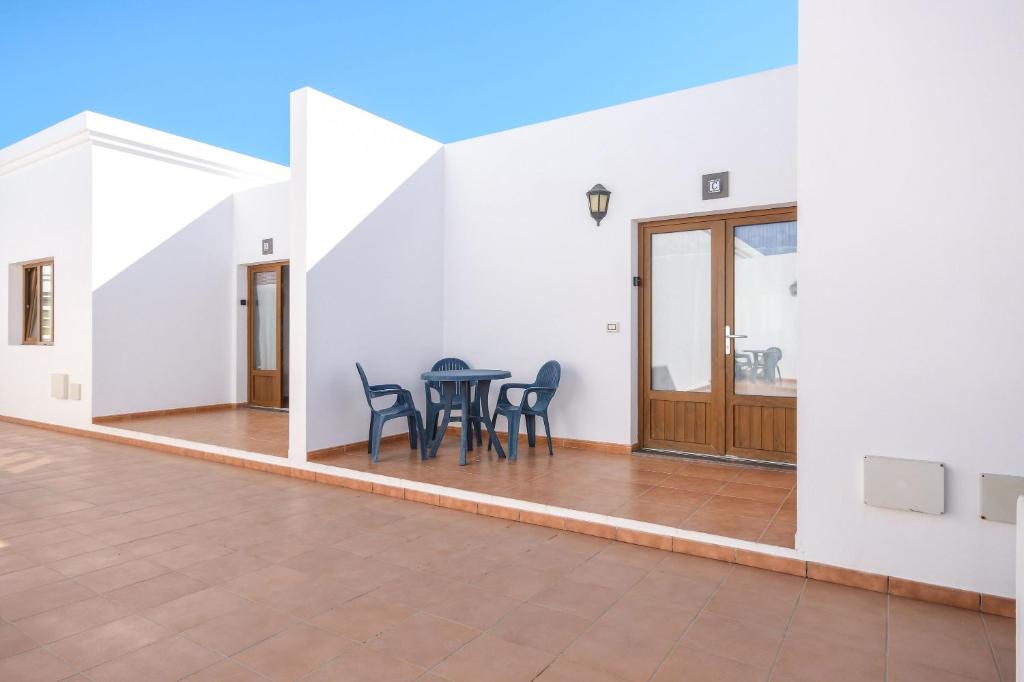 a large white room with a table and chairs at Apartamentos Flor Tres in Caleta de Sebo