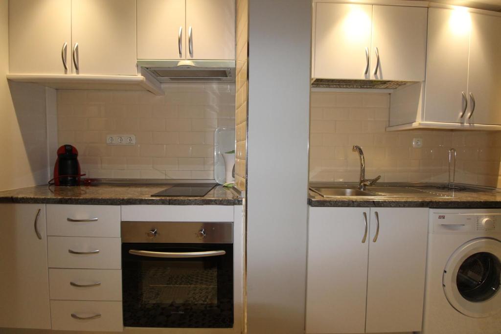 małą kuchnię z białymi szafkami i zlewem w obiekcie CENTRO ANTEQUERA Apartamento Calzada Centro w mieście Antequera
