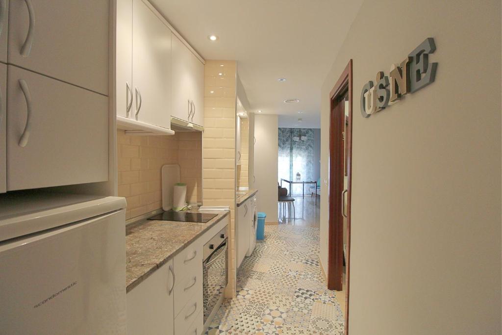 kuchnia z białymi szafkami i podłogą wyłożoną kafelkami w obiekcie CENTRO ANTEQUERA Apartamento Calzada Centro w mieście Antequera
