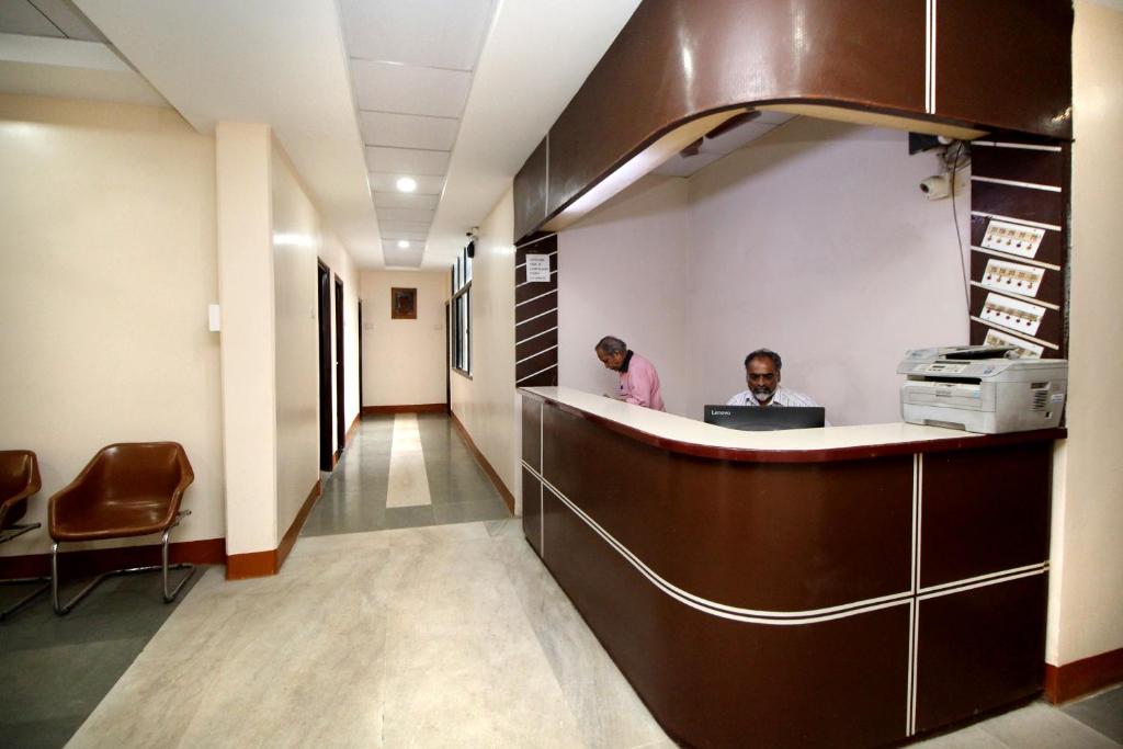two people standing at a reception desk in a hospital lobby at Hotel Gomatgiri in Aurangabad