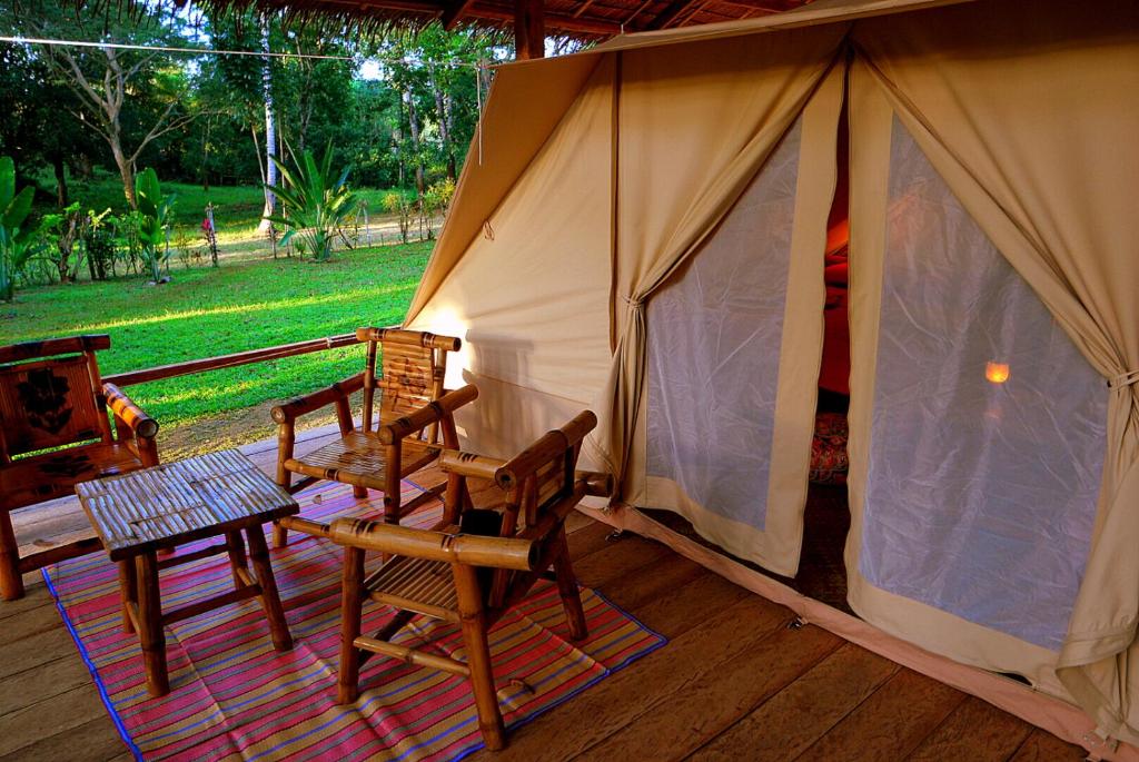 ein Zelt mit Stühlen und einem Tisch davor in der Unterkunft Pandora Glamping in Quezon