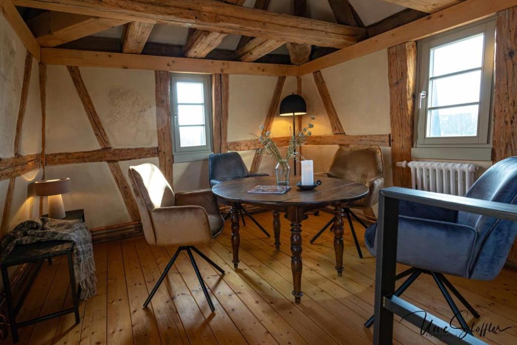 ein Esszimmer mit einem Tisch und Stühlen in einem Zimmer in der Unterkunft Ferienwohnung Türmerwohnung in Öhringen