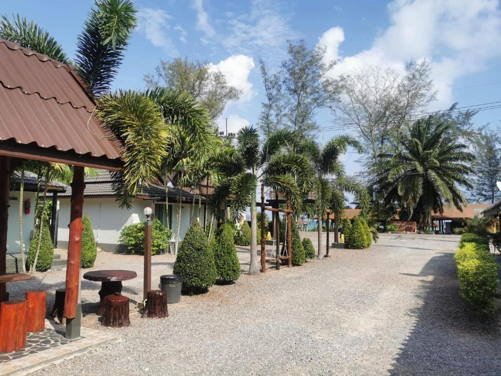 une rue avec des arbres, une table et un bâtiment dans l'établissement Lung Pod 9 resort, à Chumpon