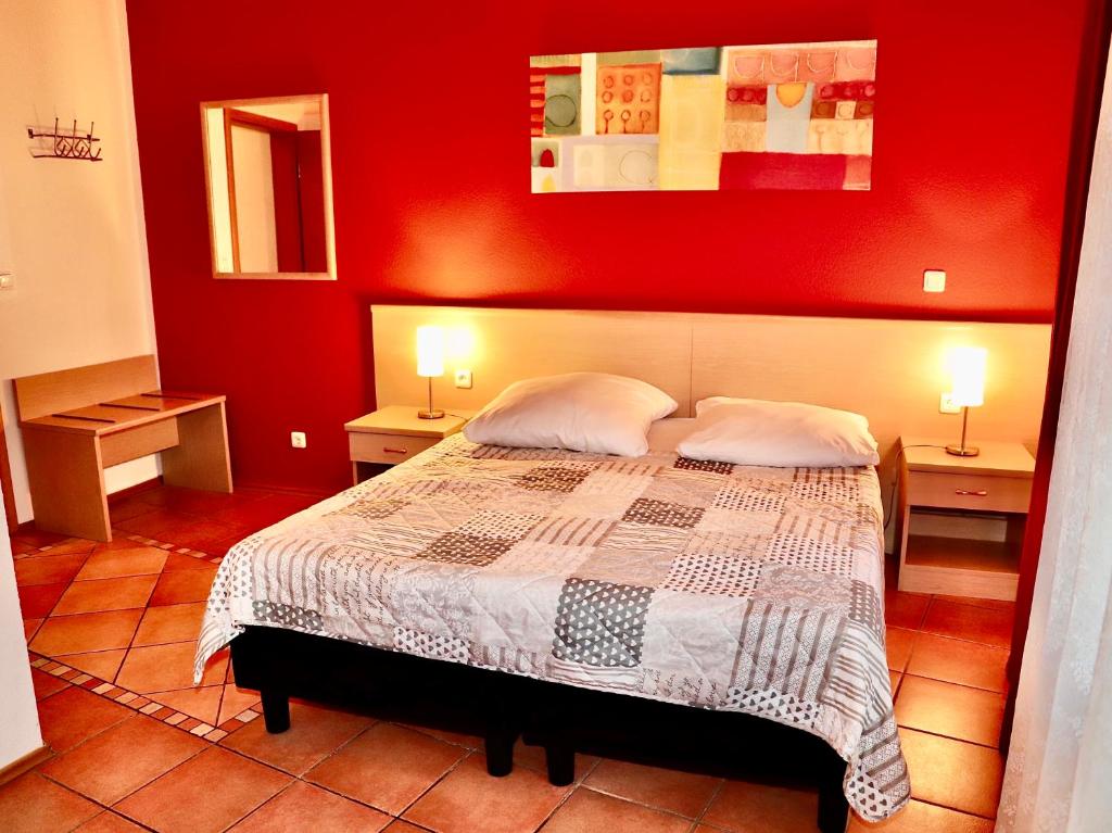 1 dormitorio rojo con 1 cama con 2 mesitas de noche en Hotel Aurelia, en Frankfurt