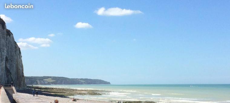 a beach with people on the sand and the ocean at Villa D'ALBATRE in Dieppe