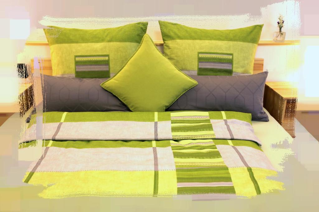 Una cama con almohadas coloridas y una manta. en elli's, en Schwabach