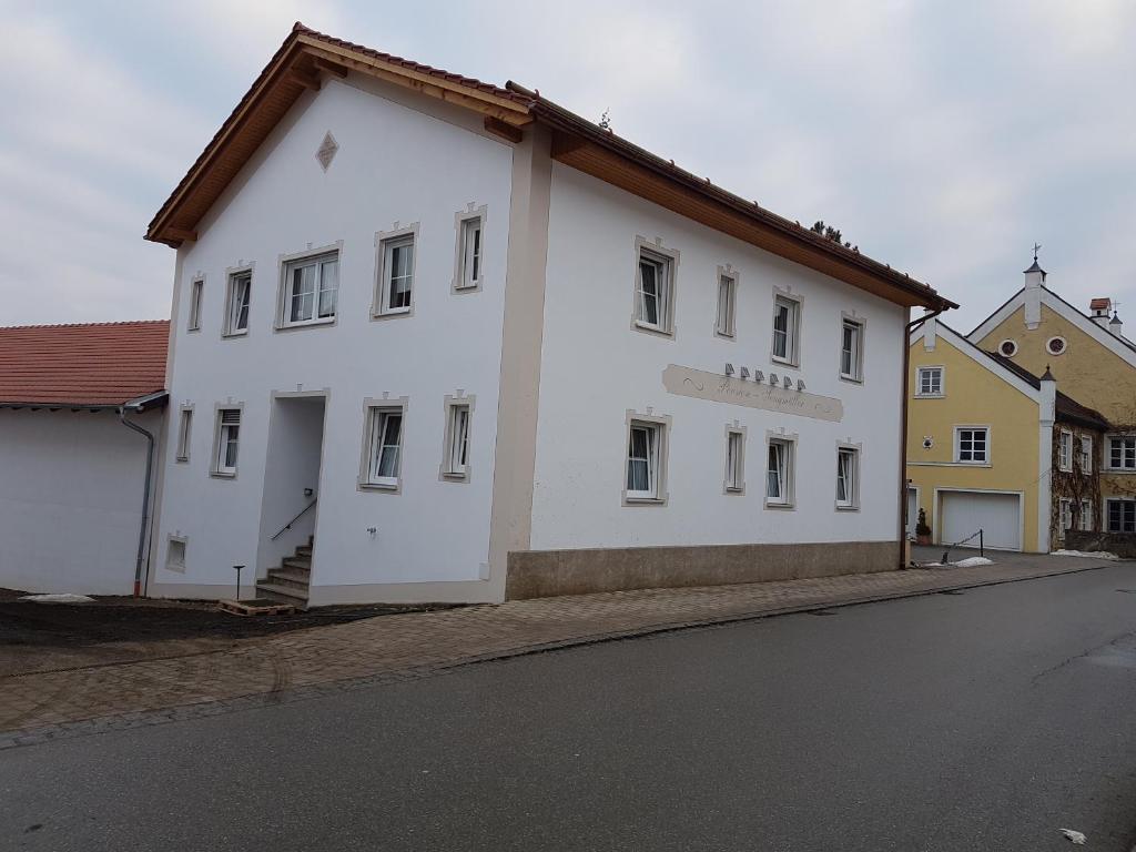 un bâtiment blanc sur le côté d'une rue dans l'établissement Pension Sengmüller, à Buchbach