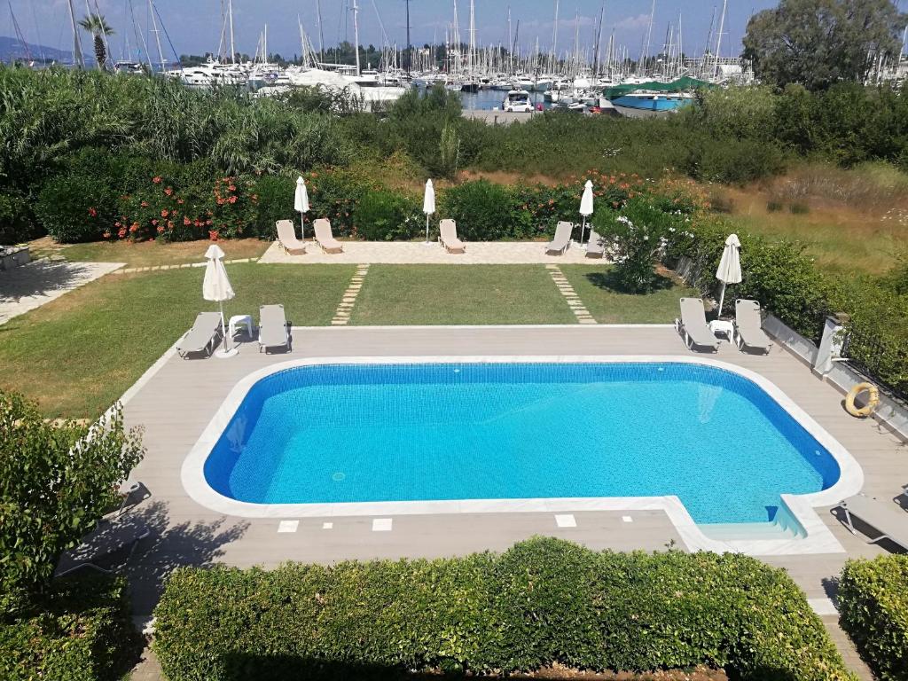 una piscina en un patio con sillas y un campo en Corfu Anastasia, en Kontokali