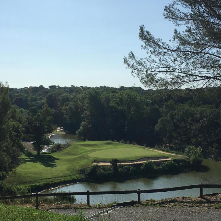- une vue aérienne sur un parcours de golf avec une rivière dans l'établissement Résidence le Clos Azur 115, à La Motte