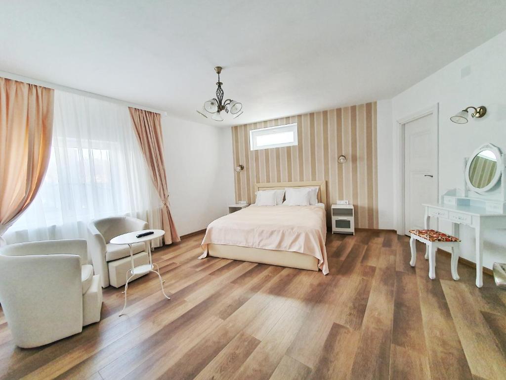 um quarto com uma cama, um sofá e uma cadeira em Tourist B&C em Curtea de Argeş