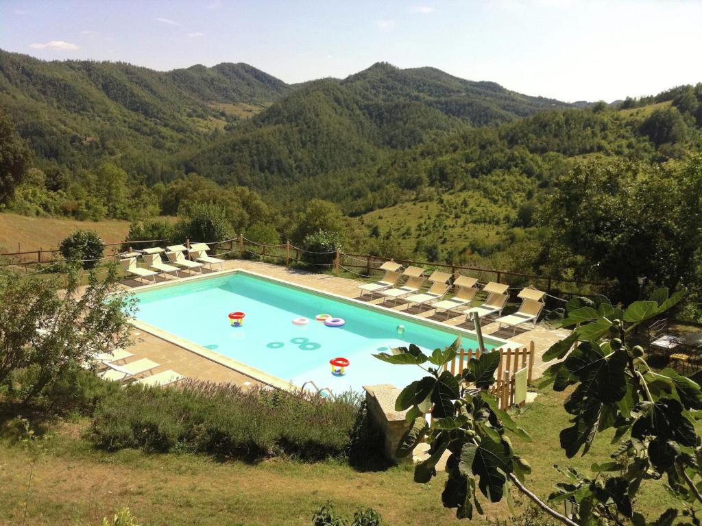 una piscina con montagne sullo sfondo di Belvilla by OYO Casal Corniolo Montalto ad Apecchio