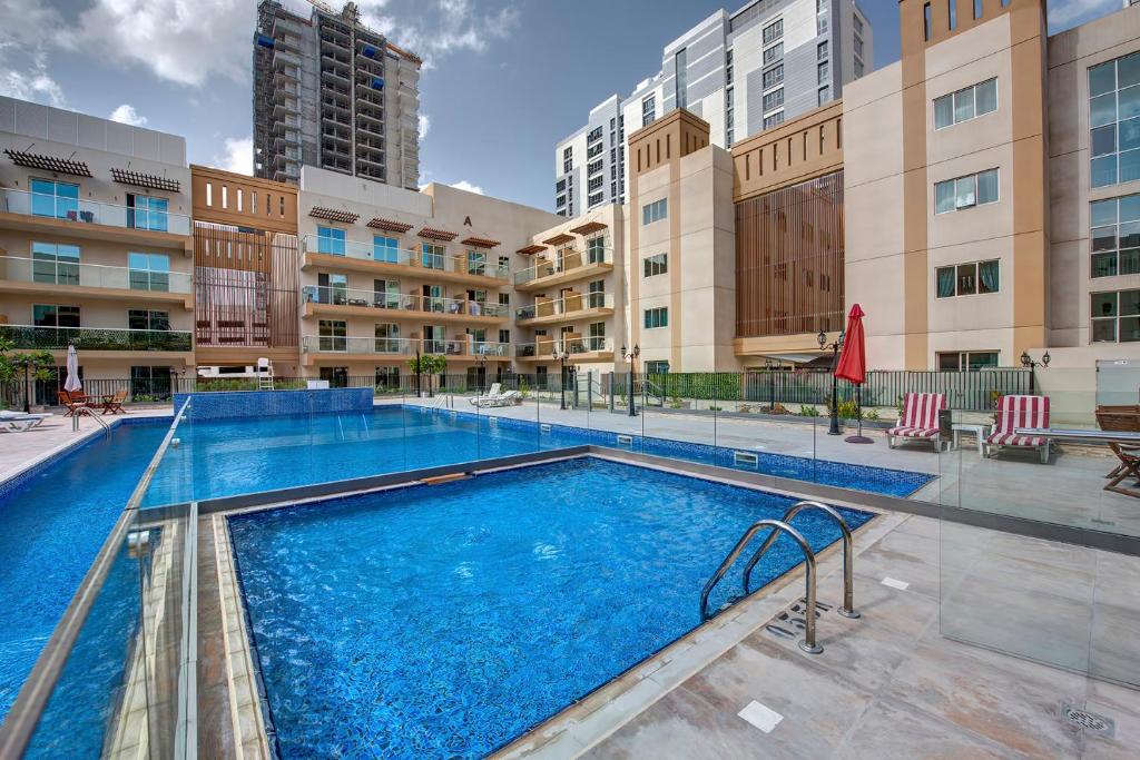 a swimming pool at a apartment complex with buildings at bnbmehomes - Classic Studio Apt in the heart of JVC - 214 in Dubai