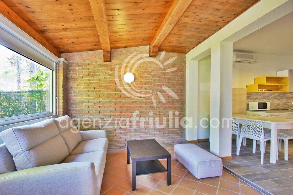 salon z kanapą i stołem w obiekcie Villa Conchiglia w Lignano Sabbiadoro