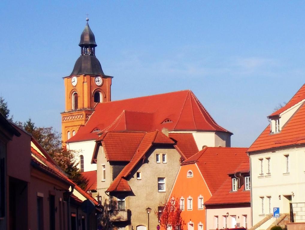 a large building with a clock tower in a city at Castrum Bucowe in Buckow