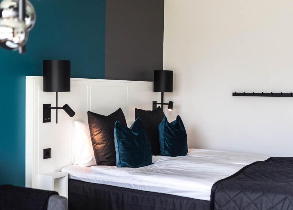 a bedroom with a white bed with blue pillows at Sky Hotel City Apartments in Linköping