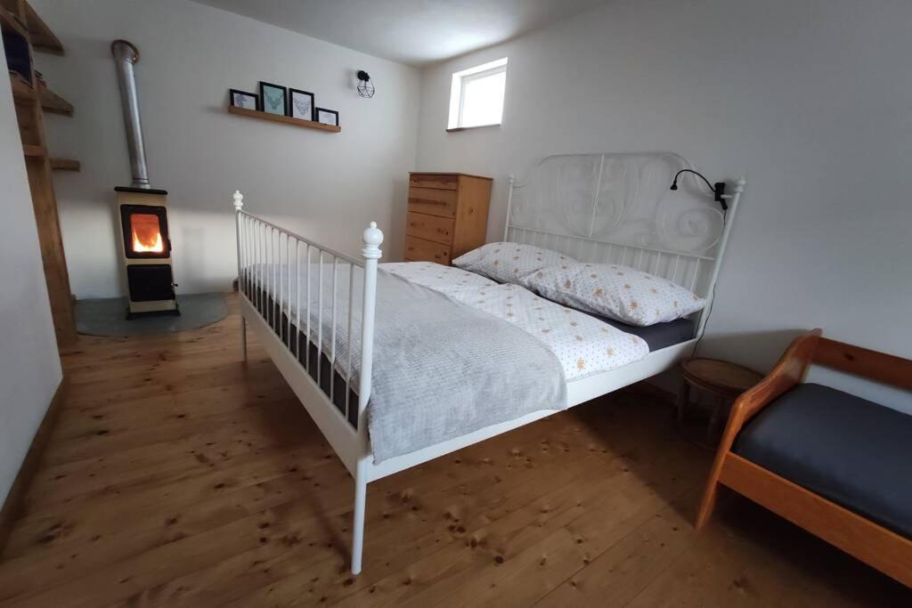 białe łóżko w pokoju z kominkiem w obiekcie Ubytovanie v Banskej Bystrici - dom s terasou w Bańskiej Bystrzycy