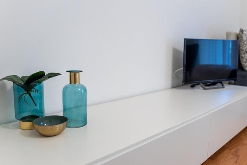 a white counter with a tv and a vase and a vase at B&B CASA PALMANOVA in Catania