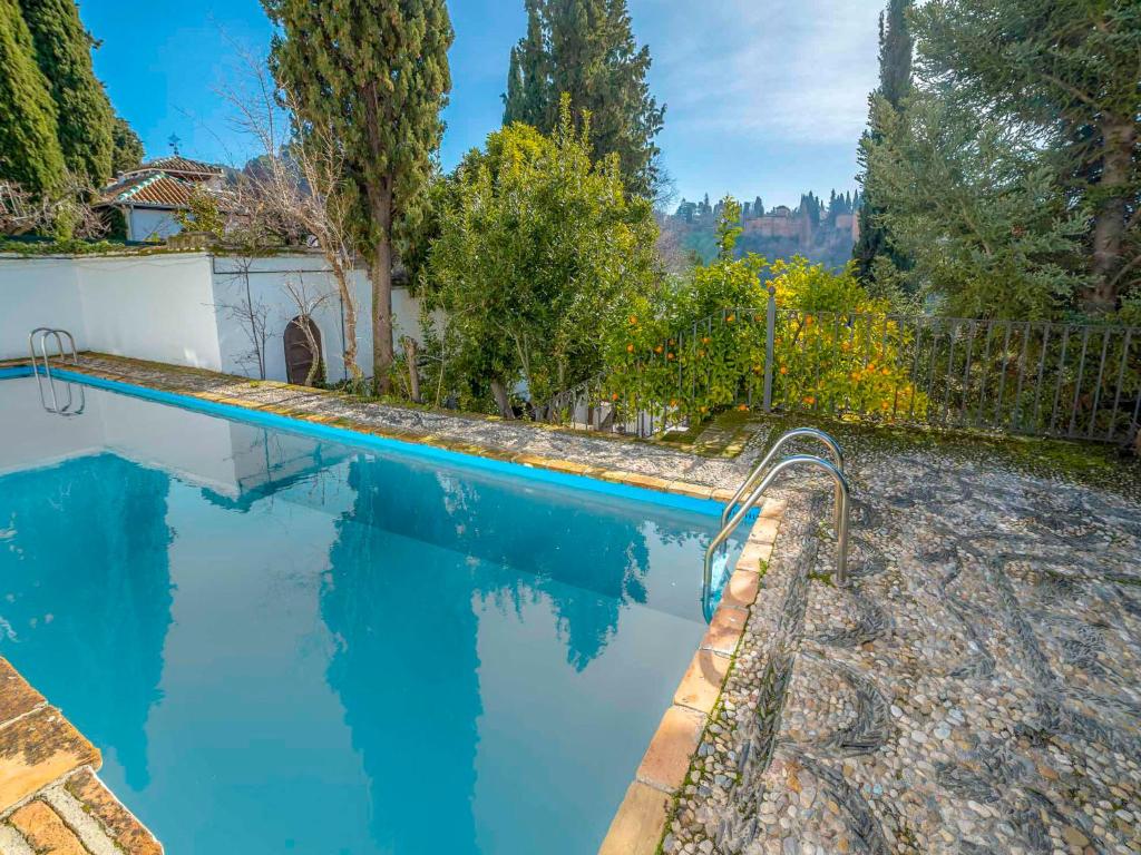 a swimming pool with blue water in a yard at Holiday Home Carmen Del Agua by Interhome in Granada