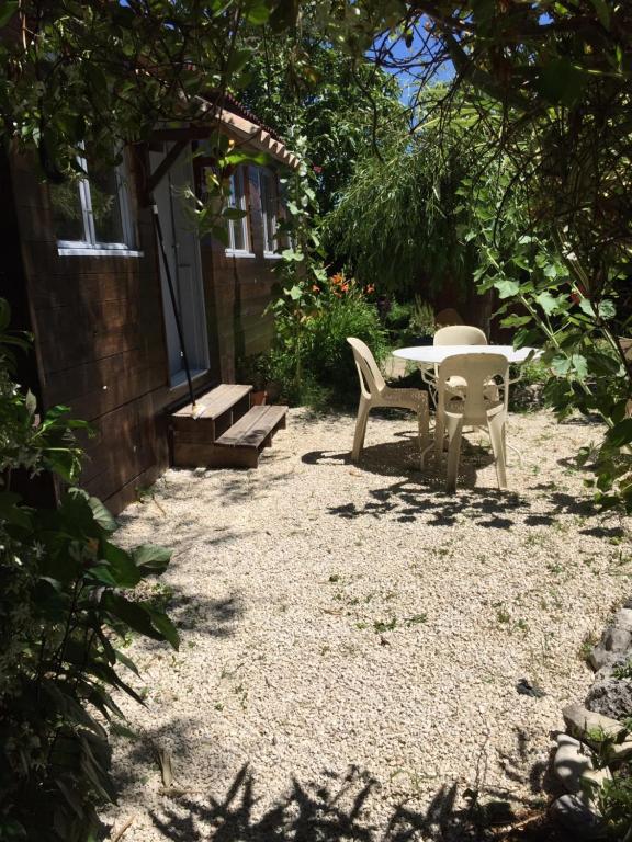 a patio with a table and chairs in a yard at La maison des loirs in Valréas
