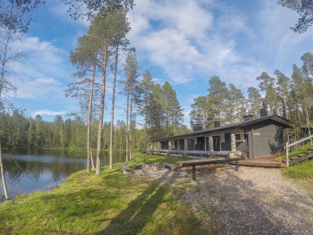 eine Hütte im Wald neben einem See in der Unterkunft Holiday Home Sompsanniemi by Interhome in Ruka