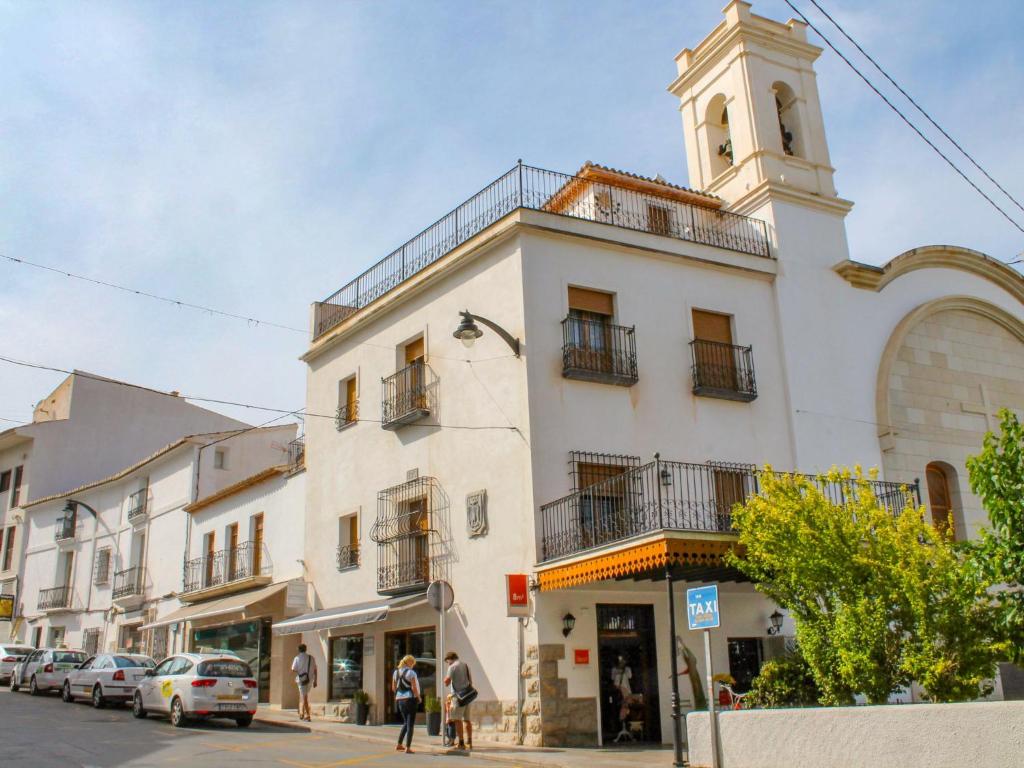 um edifício branco com uma torre de relógio numa rua em Apartment Bernia by Interhome em Altea