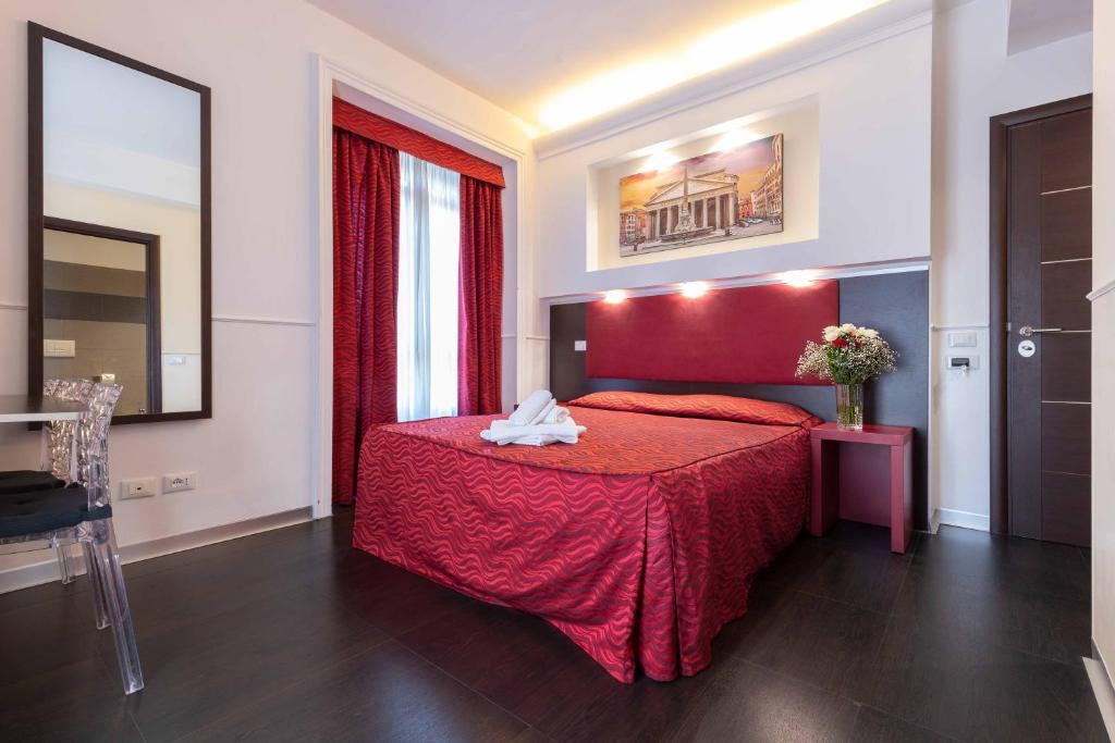 ein Hotelzimmer mit einem roten Bett mit einer roten Decke in der Unterkunft Imperial Suite Guest House in Rom