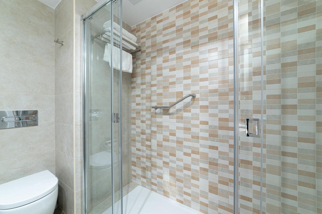 a bathroom with a toilet and a glass shower at Pato Rojo in Punta Umbría