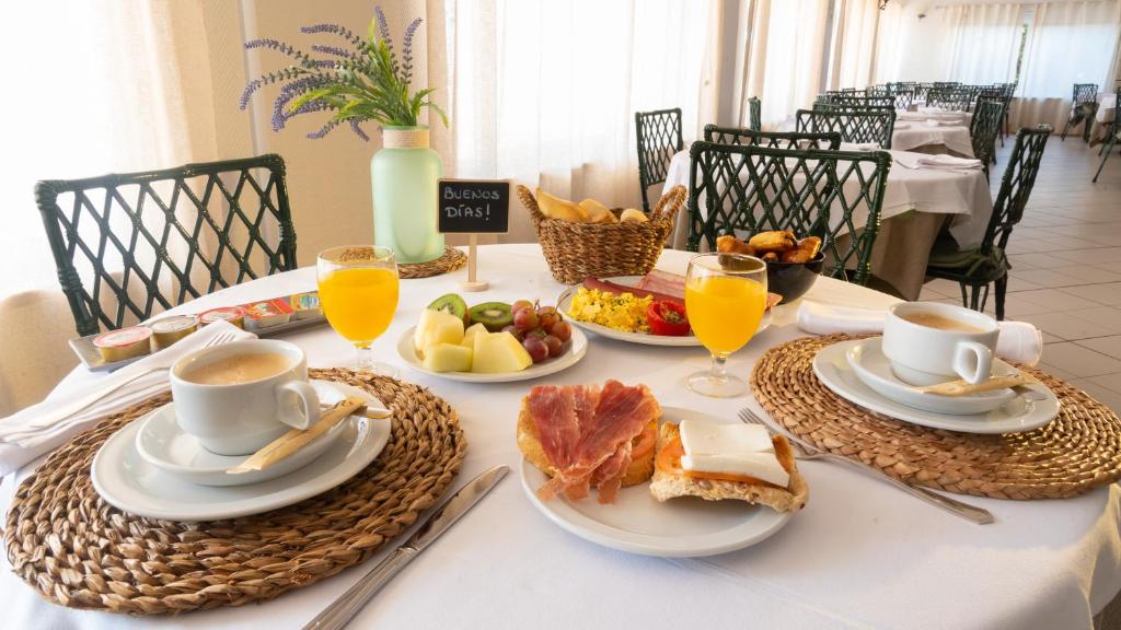 a table with breakfast foods and drinks on it at Pato Rojo in Punta Umbría