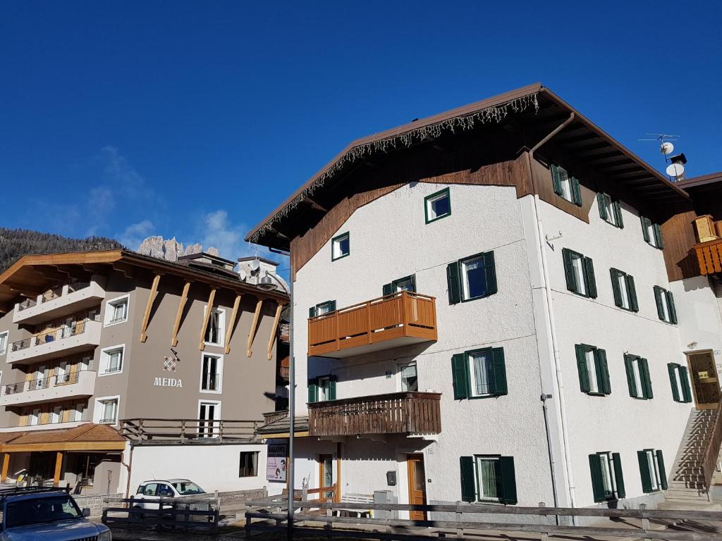 um grande edifício branco com um telhado de madeira em Casa Paola em Pozza di Fassa