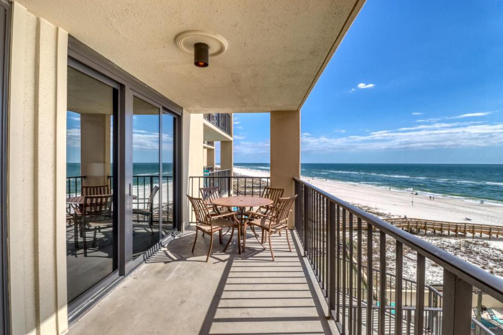 einen Balkon mit Tisch und Stühlen sowie Strand in der Unterkunft Phoenix I #1046 in Orange Beach