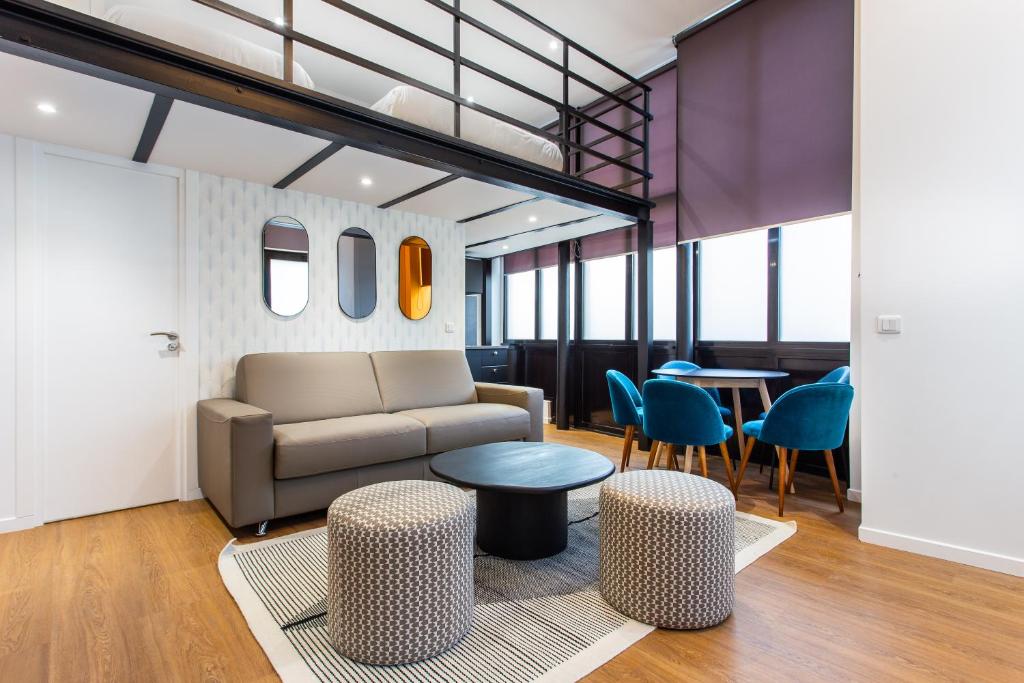 a living room with a couch and a table and chairs at Luxury loft in paris in Paris