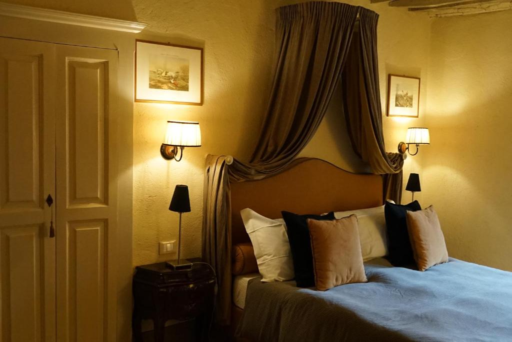 um quarto com uma cama com almofadas e cortinas em LOCANDA IL CANOVACCIO em Campiglia Marittima