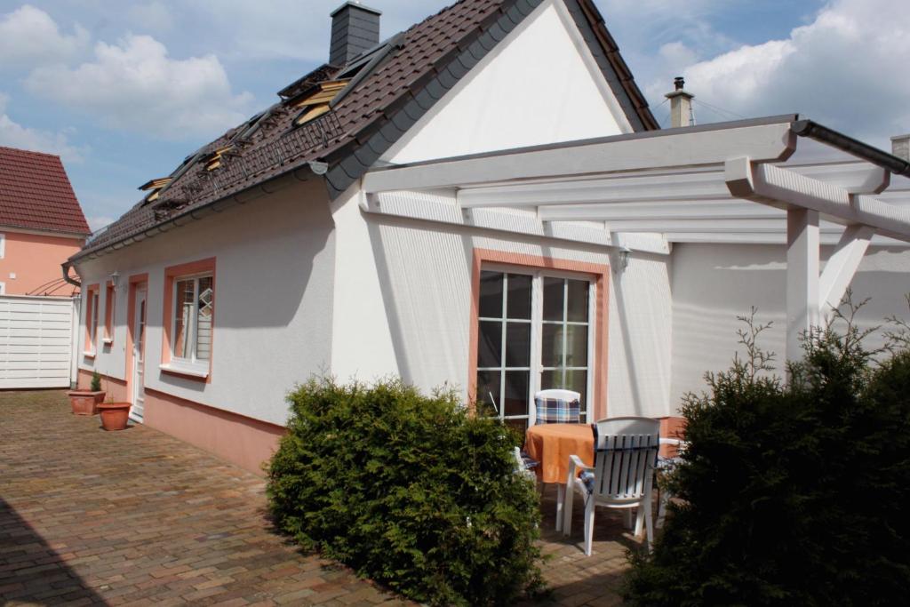 uma casa branca com mesa e cadeiras em Ferienhaus Schild em Elsterheide
