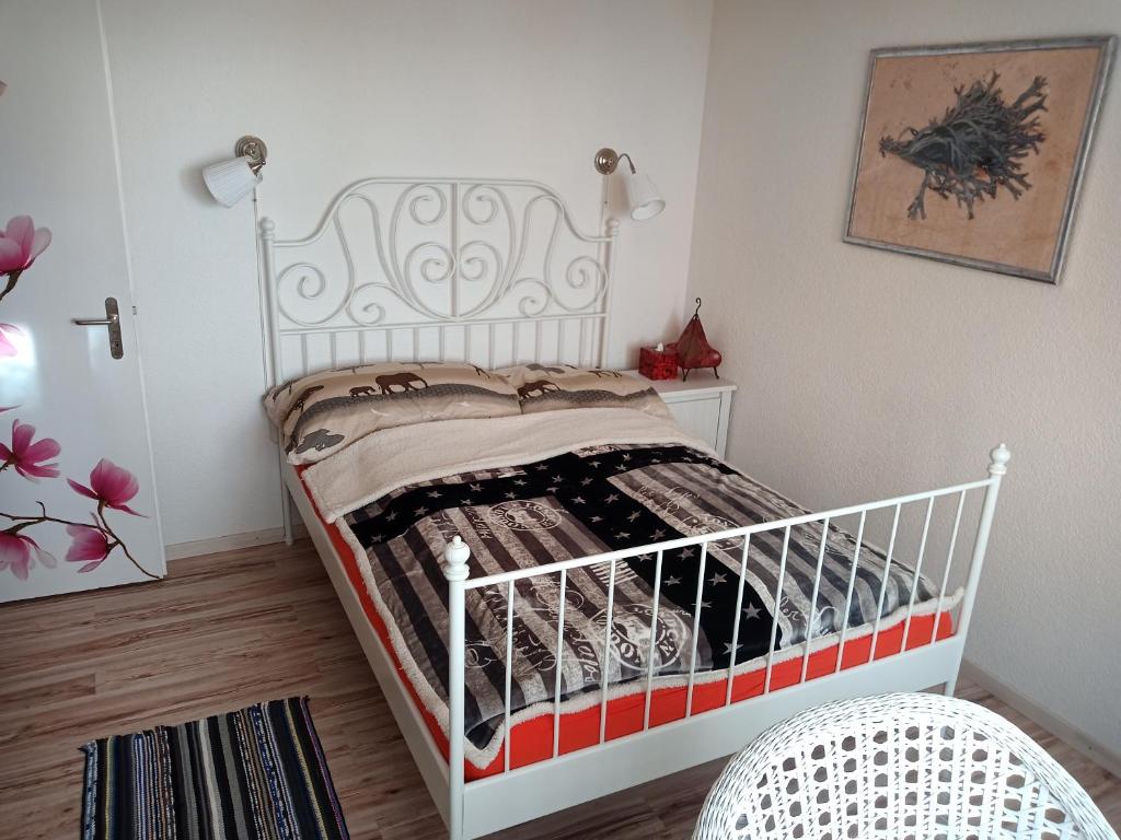 Un pequeño dormitorio con una cama blanca en una habitación en B&B Im Bitzi, en Zuzwil