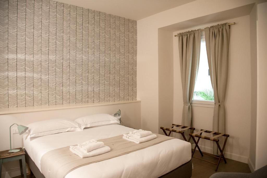 a bedroom with a bed with two towels on it at Pietrapiana Boutique Apartments in Florence