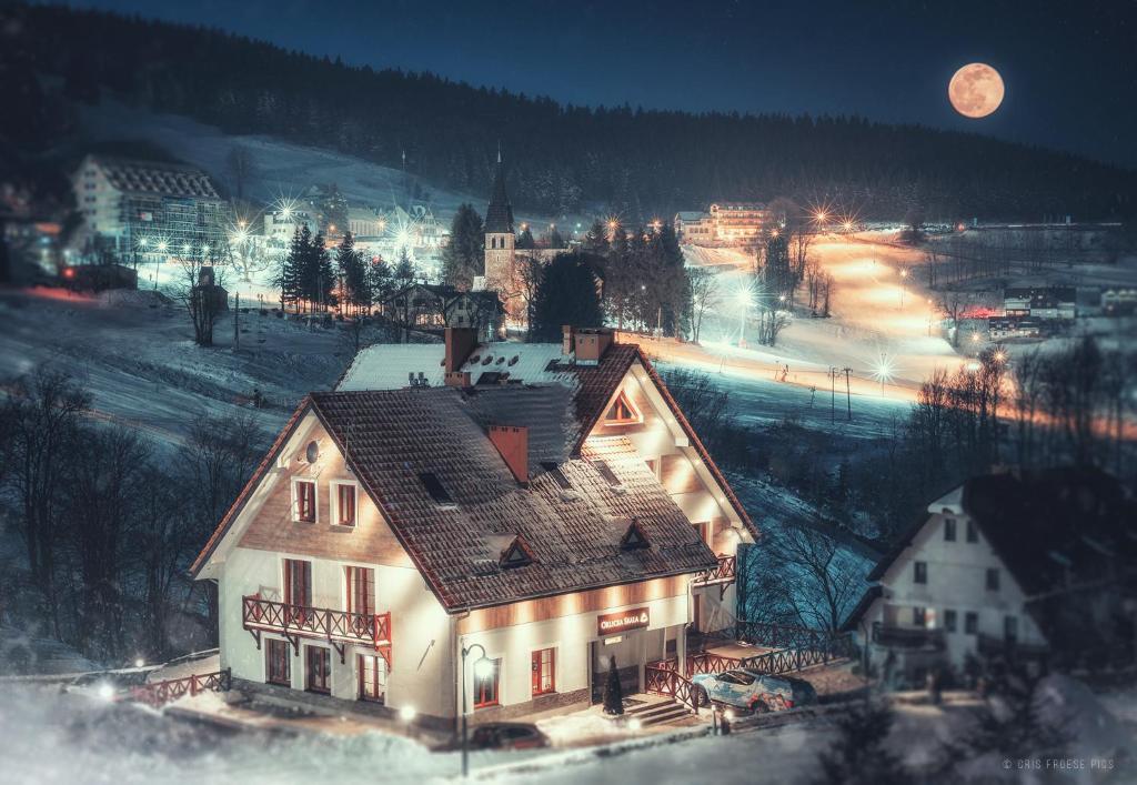 a large house with a roof in a town at night at Orlicka Skała in Zieleniec