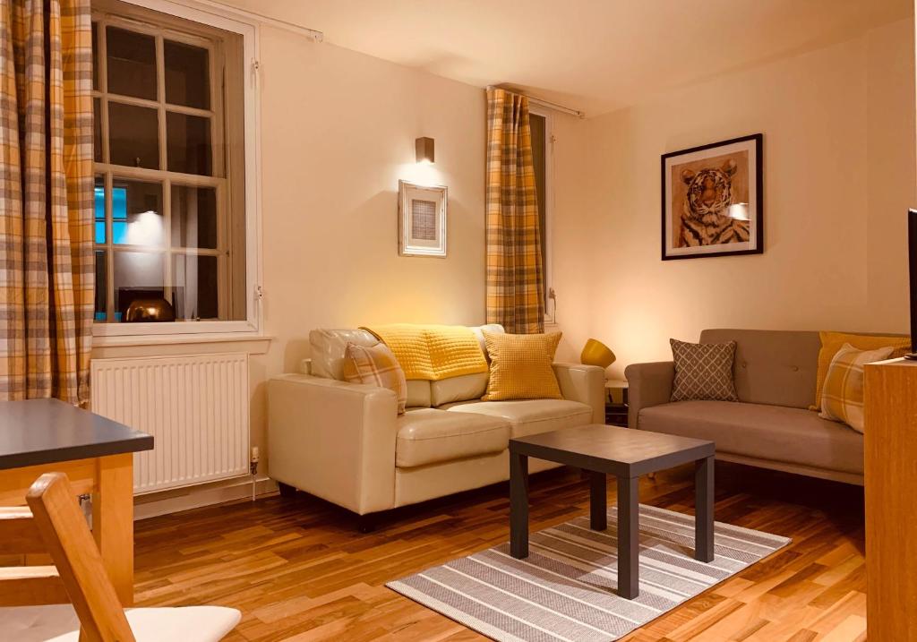 uma sala de estar com um sofá e uma mesa em The Cowgatehead Residence em Edimburgo