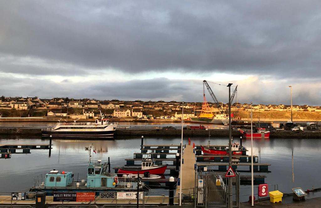 a group of boats are docked in a harbor at The Steamboat - A Flat with Amazing Harbour Views in Wick