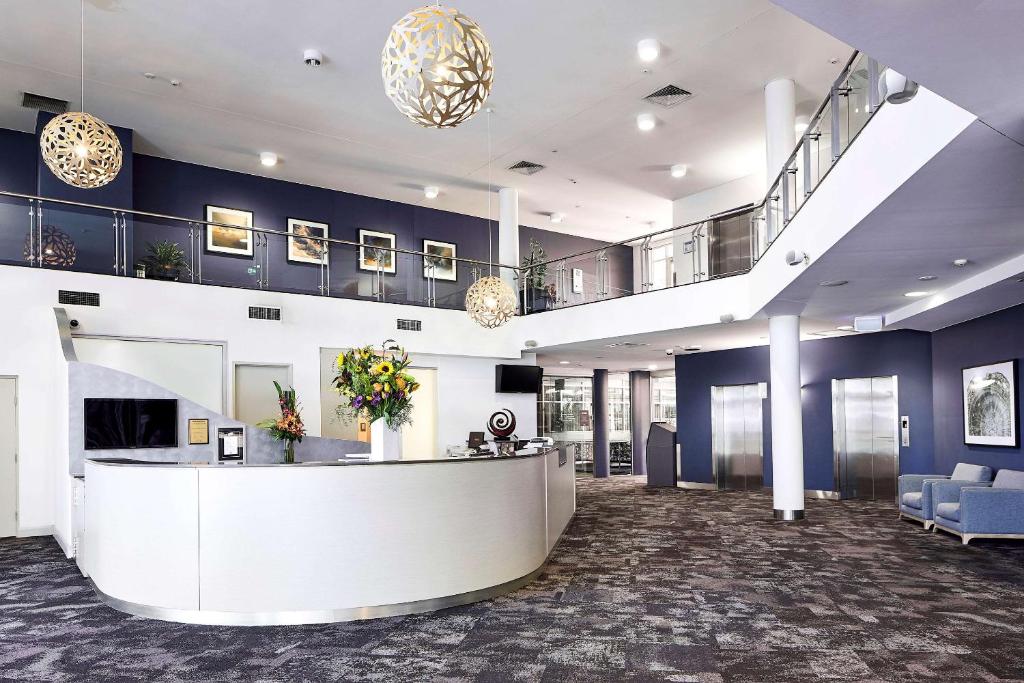 an office lobby with a reception desk and a staircase at Quality Hotel Dickson in Canberra