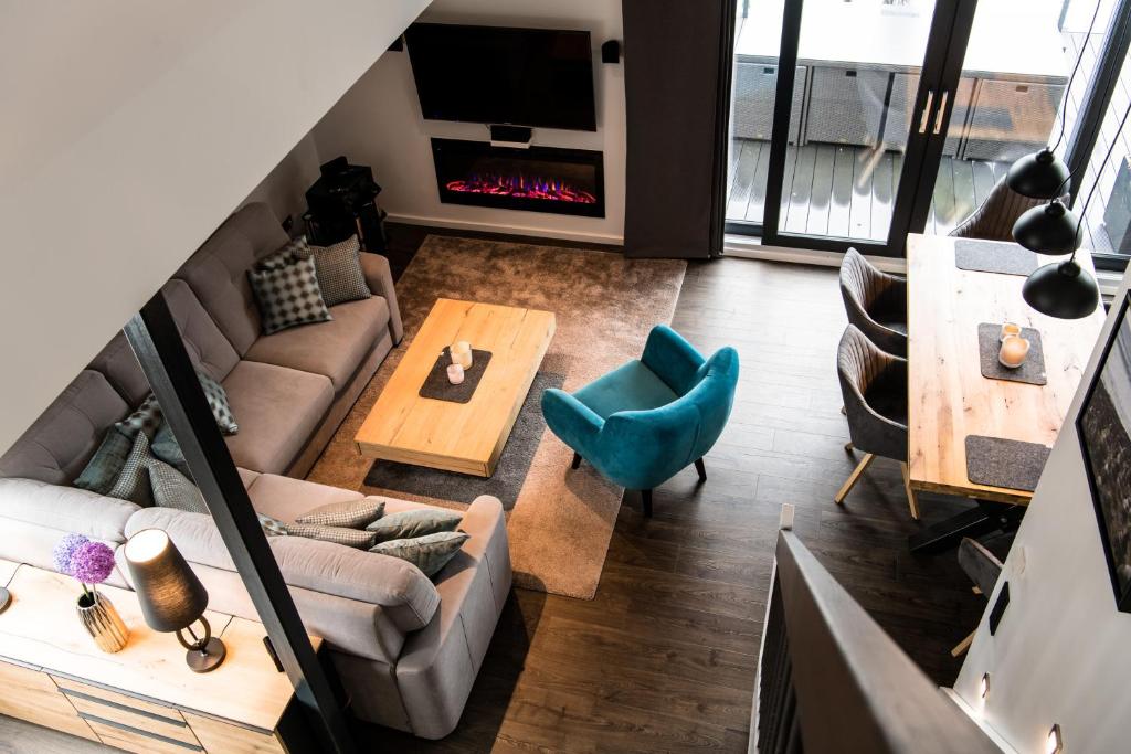 a living room with a couch and a table and a fireplace at Ocean House Penthousewohnung Wolke 7 mit Whirlpool in Timmendorfer Strand